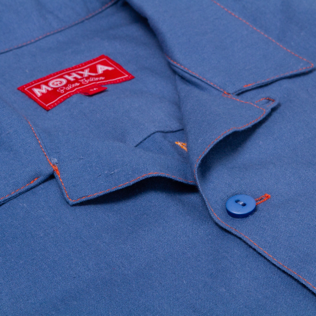 Close-up of a blue shirt with a red label on the collar.
