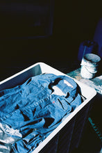 Load image into Gallery viewer, photo of the shirt in a bick bucket at the laundry place here in athens

